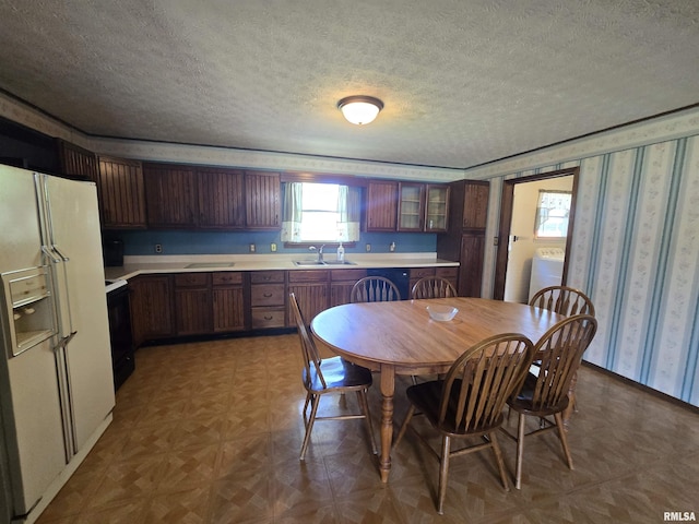 dining room featuring washer / dryer, wallpapered walls, and a textured ceiling