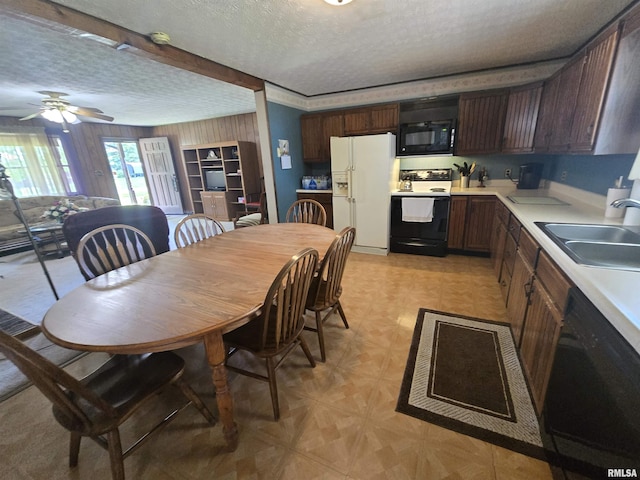 kitchen featuring black microwave, white refrigerator with ice dispenser, a sink, electric stove, and dishwashing machine