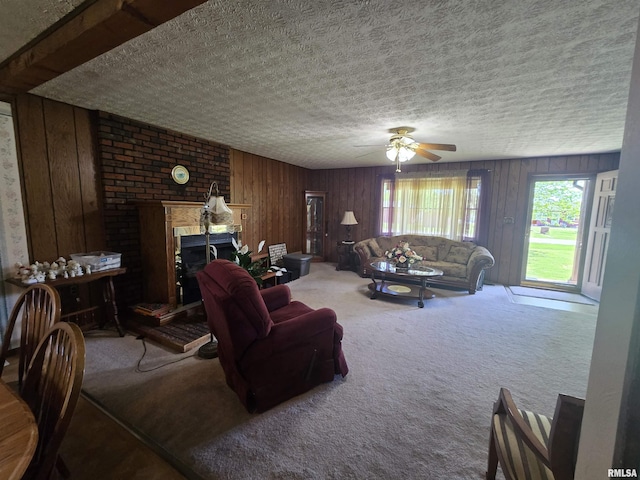 carpeted living room featuring wood walls, a textured ceiling, and ceiling fan