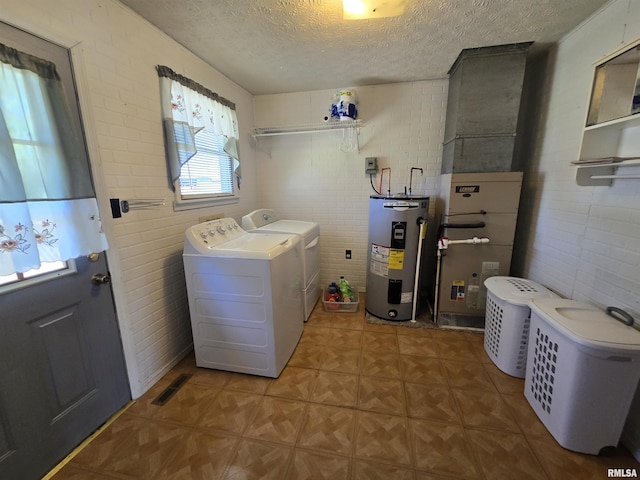 laundry room featuring laundry area, a textured ceiling, visible vents, water heater, and washer and clothes dryer