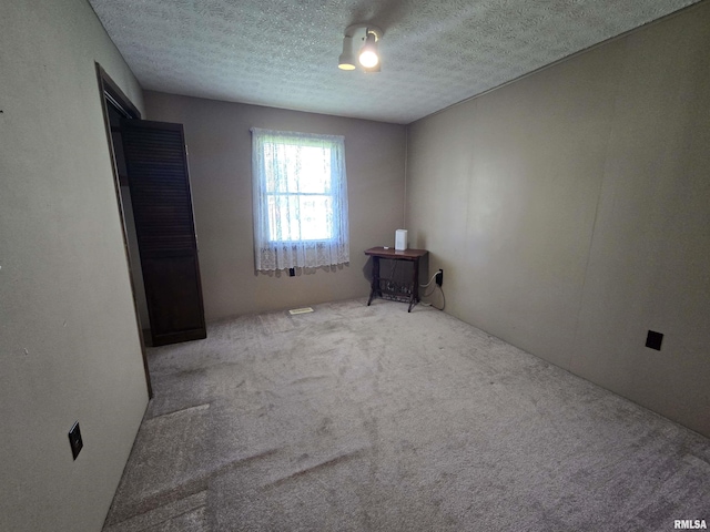 unfurnished bedroom featuring carpet flooring and a textured ceiling