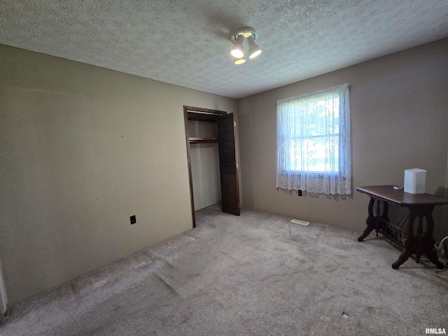 bedroom with a closet, a textured ceiling, and carpet