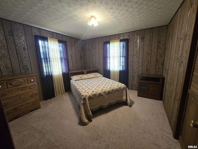 carpeted bedroom with wooden walls and a textured ceiling