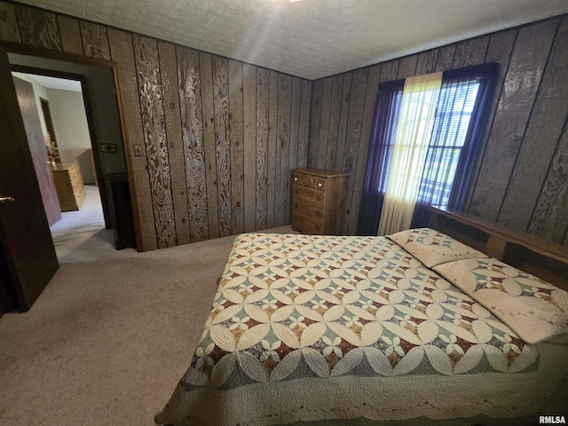 carpeted bedroom with wood walls and a textured ceiling