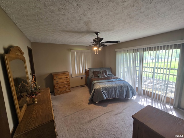 bedroom featuring carpet floors, ceiling fan, and a textured ceiling