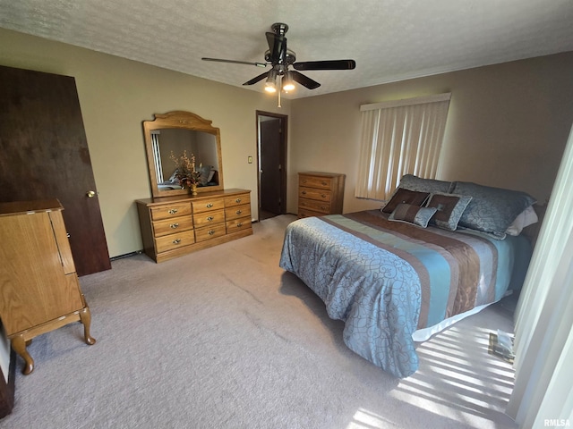 bedroom featuring carpet floors, a ceiling fan, and a textured ceiling