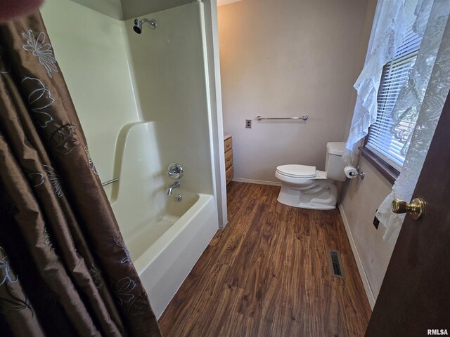 bathroom featuring shower / bath combination with curtain, visible vents, wood finished floors, baseboards, and toilet