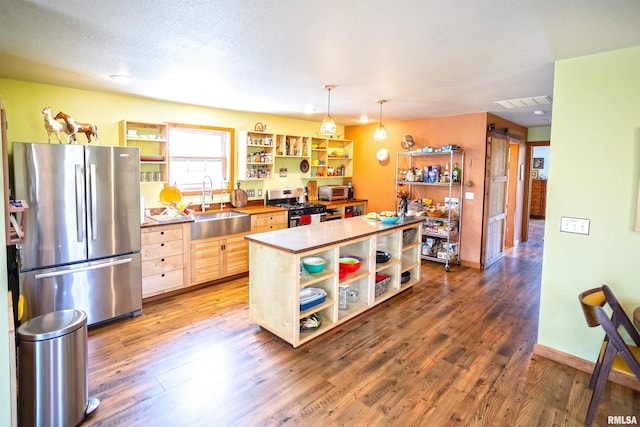 kitchen with stainless steel appliances, open shelves, light wood-style flooring, and a sink