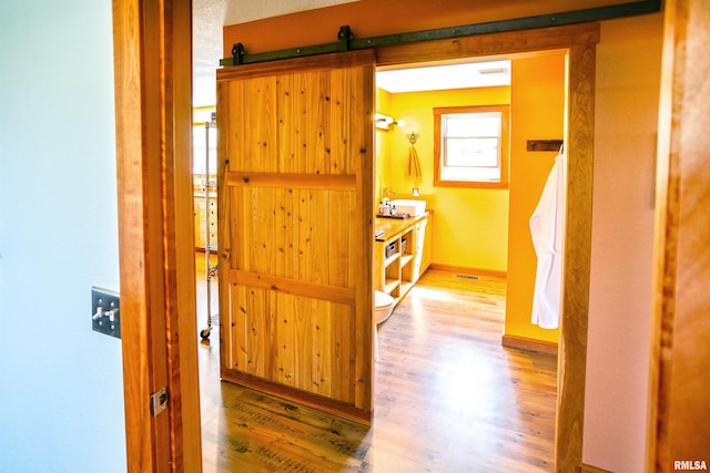 hall featuring wood finished floors and baseboards