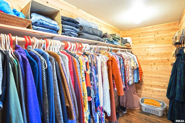 walk in closet with wood finished floors