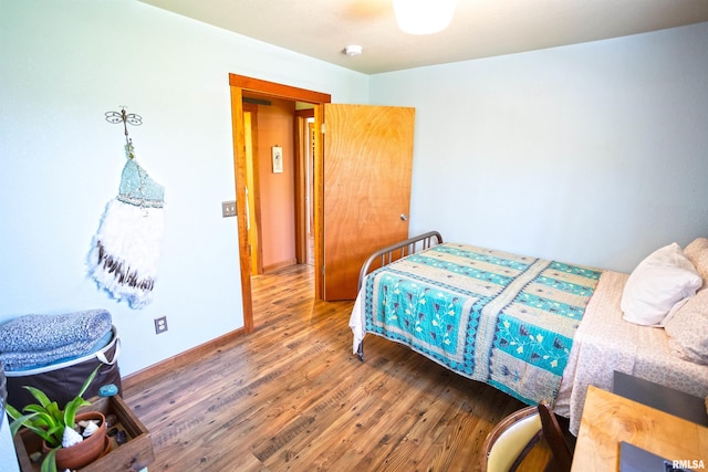 bedroom featuring wood finished floors and baseboards