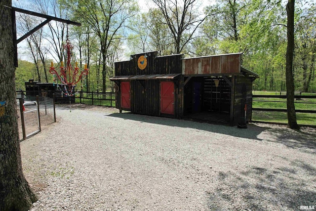 exterior space featuring fence, an exterior structure, and an outbuilding