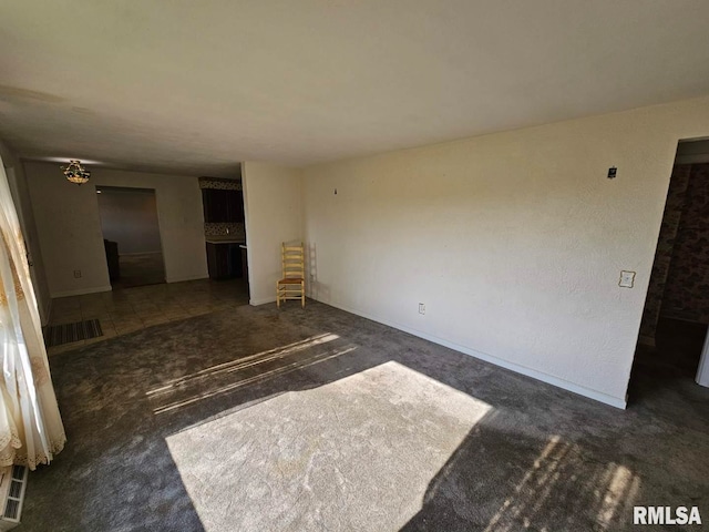 unfurnished living room featuring baseboards and carpet