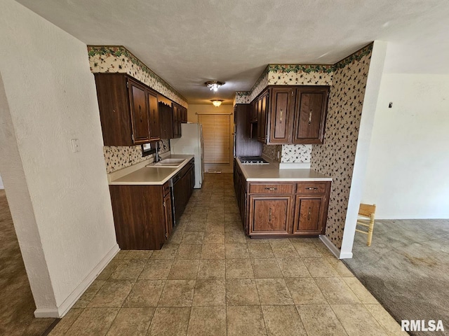 kitchen featuring light countertops, baseboards, decorative backsplash, and a sink