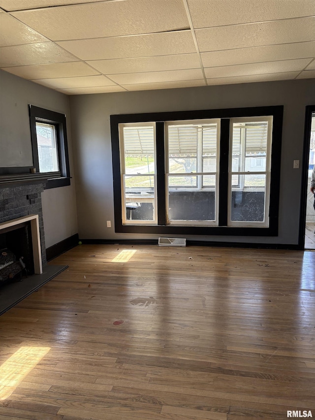 920 S 12th St, Herrin, IL 62948 - unfurnished living room featuring baseboards, visible vents, a drop ceiling, and hardwood / wood-style flooring