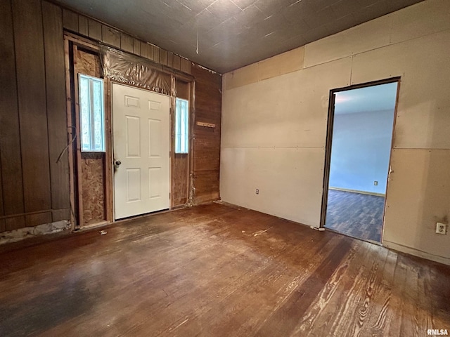 entrance foyer with wood walls and hardwood / wood-style flooring