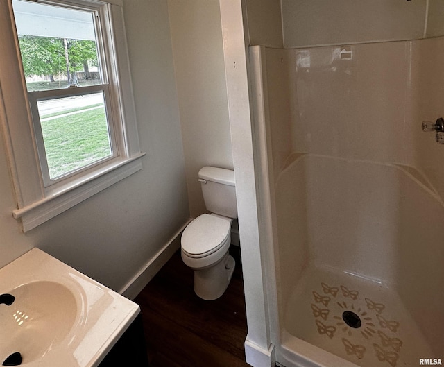 800 Division St, Carterville, IL 62918 - bathroom with vanity, wood finished floors, toilet, baseboards, and a stall shower