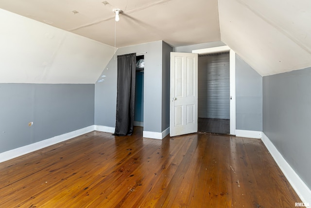 additional living space with baseboards, lofted ceiling, and hardwood / wood-style flooring