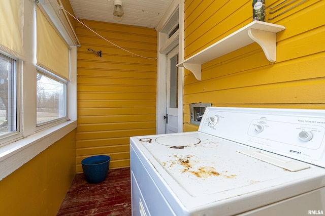 clothes washing area featuring laundry area, wood walls, and washer / dryer