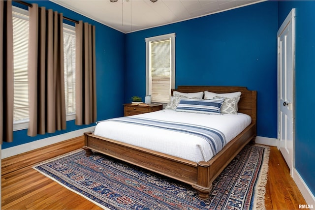 bedroom featuring baseboards, ceiling fan, and wood finished floors