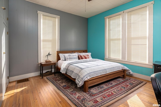 bedroom with visible vents, baseboards, and hardwood / wood-style flooring