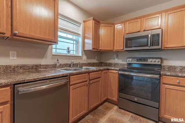 kitchen with a sink, appliances with stainless steel finishes, and dark countertops