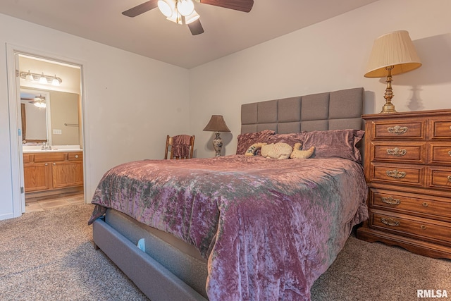 bedroom with light carpet, a ceiling fan, and ensuite bath