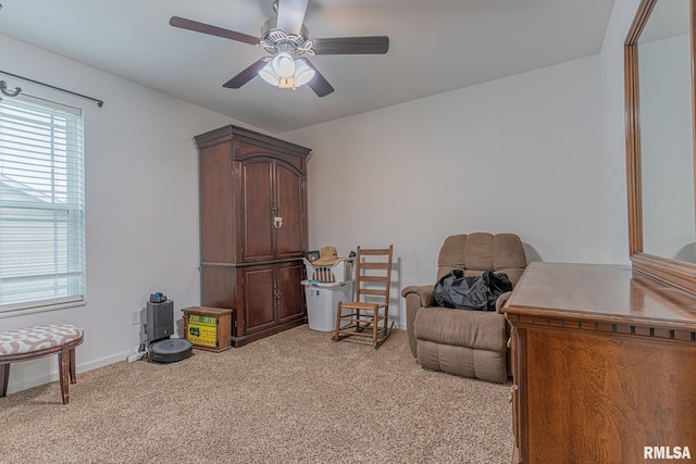 sitting room with a healthy amount of sunlight, baseboards, ceiling fan, and light colored carpet