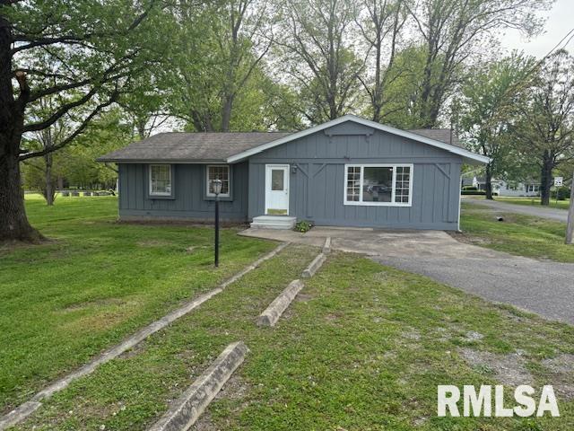 301 S Pershing St, Energy, IL 62933 - view of front facade featuring board and batten siding, aphalt driveway, and a front yard