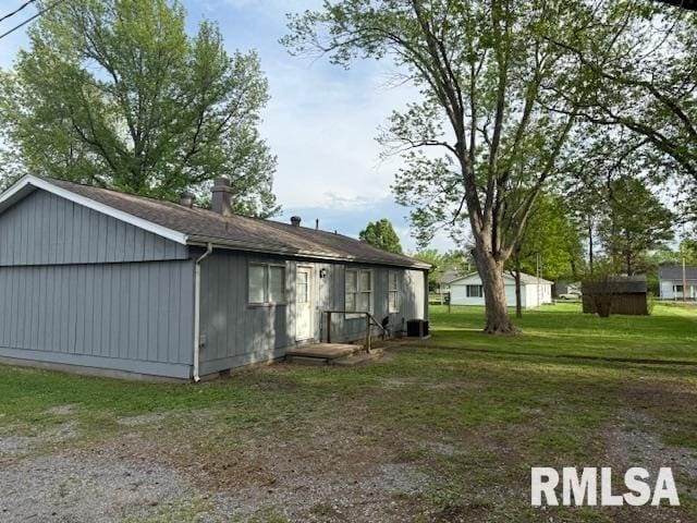 301 S Pershing St, Energy, IL 62933 - back of property featuring a lawn, central air condition unit, and a chimney