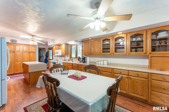 dining room with ceiling fan and light wood finished floors