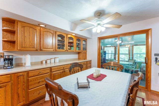 dining area with light wood finished floors and ceiling fan