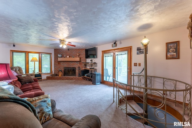living area with plenty of natural light, a ceiling fan, carpet flooring, and a textured ceiling