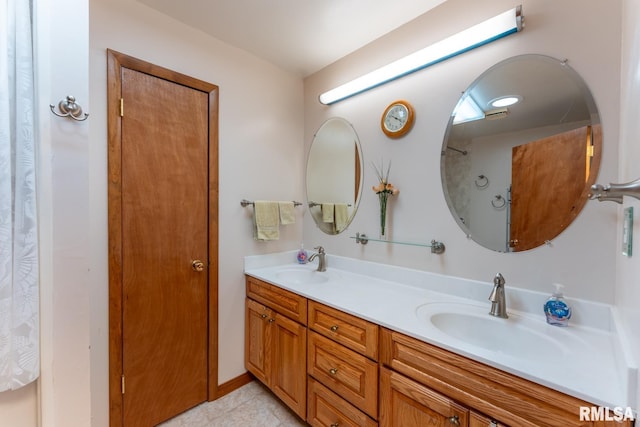 full bath with double vanity, a sink, and tile patterned flooring