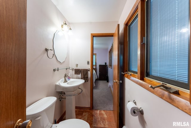 bathroom with toilet and marble finish floor