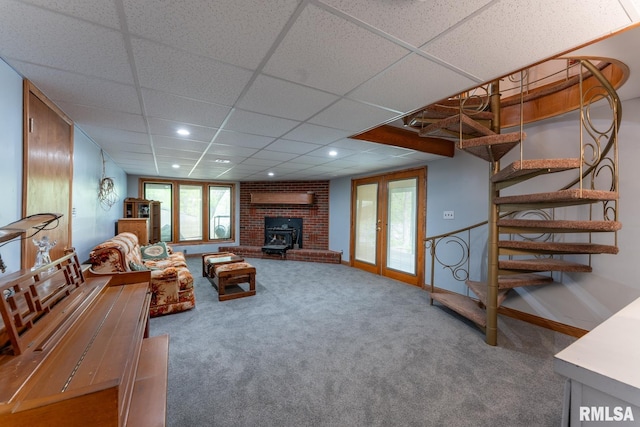 living area featuring stairway, baseboards, carpet, and a drop ceiling