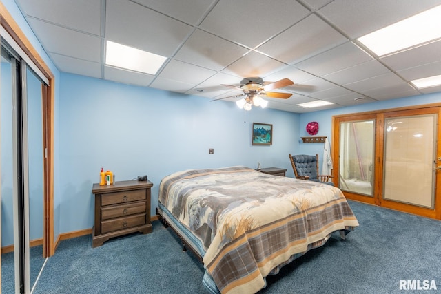 bedroom featuring carpet flooring, ceiling fan, and a drop ceiling