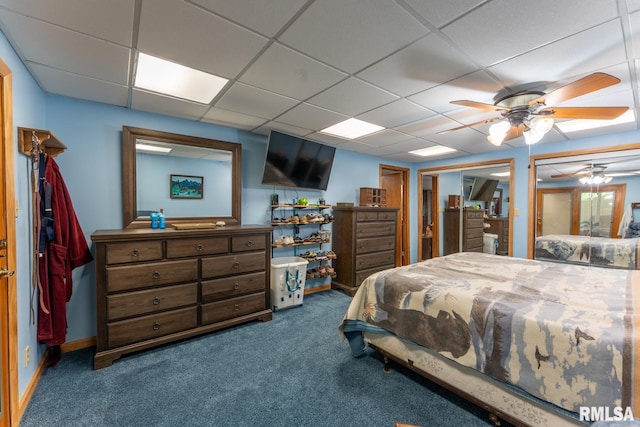 carpeted bedroom featuring a ceiling fan and a paneled ceiling