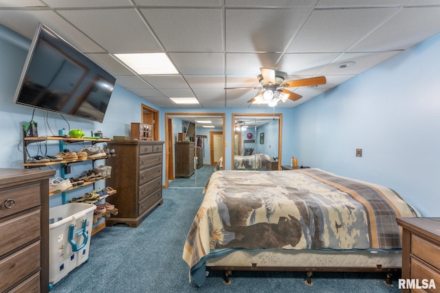 bedroom with dark colored carpet and a paneled ceiling