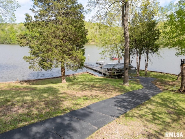 view of dock featuring a lawn and a water view