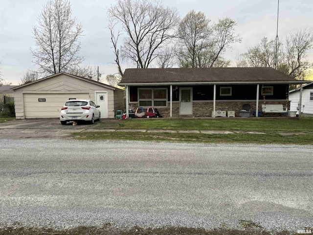 ranch-style home with a garage, a front lawn, and an outbuilding
