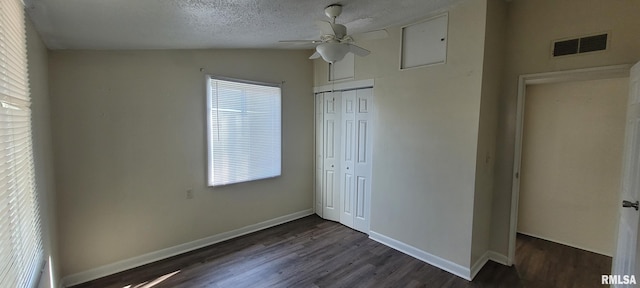 unfurnished bedroom featuring visible vents, vaulted ceiling, baseboards, a closet, and dark wood-style floors