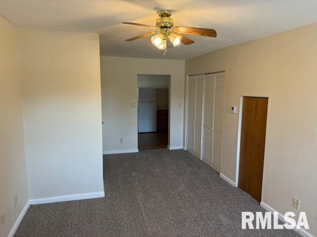 carpeted empty room with baseboards and ceiling fan