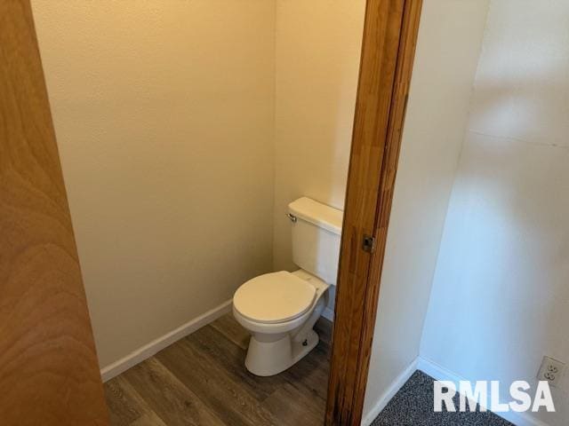 bathroom with baseboards, toilet, and wood finished floors