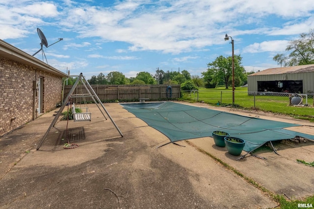 view of pool with fence, a fenced in pool, a diving board, and a patio
