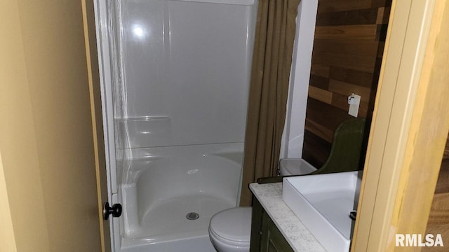 full bathroom featuring vanity, a shower, and toilet