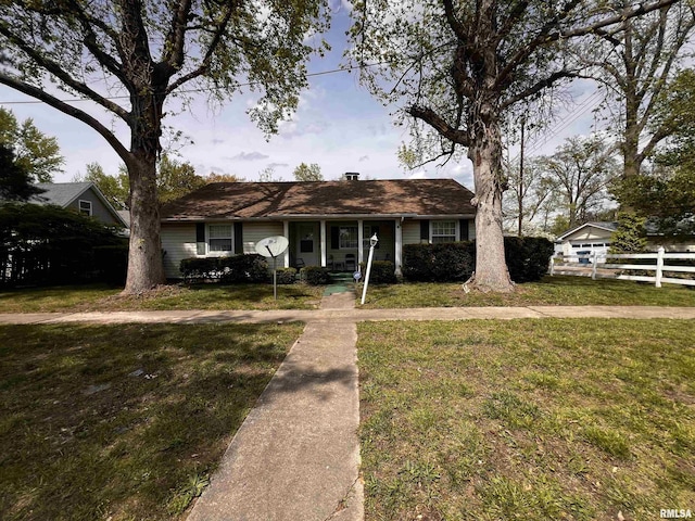 ranch-style home featuring a porch, fence, and a front yard