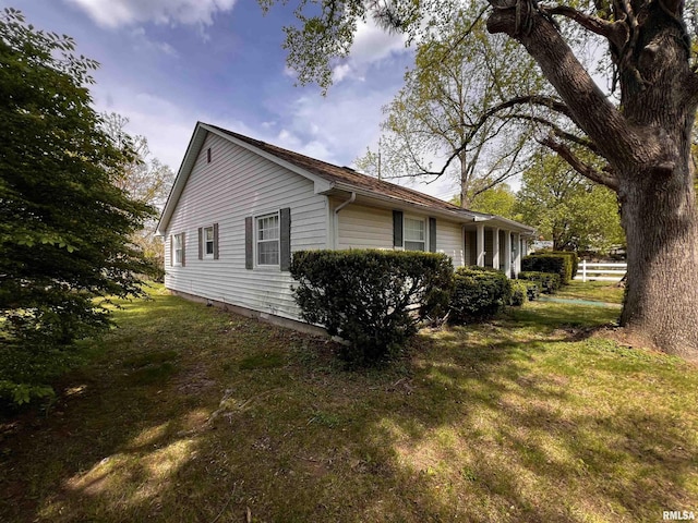 view of side of home with a yard and fence