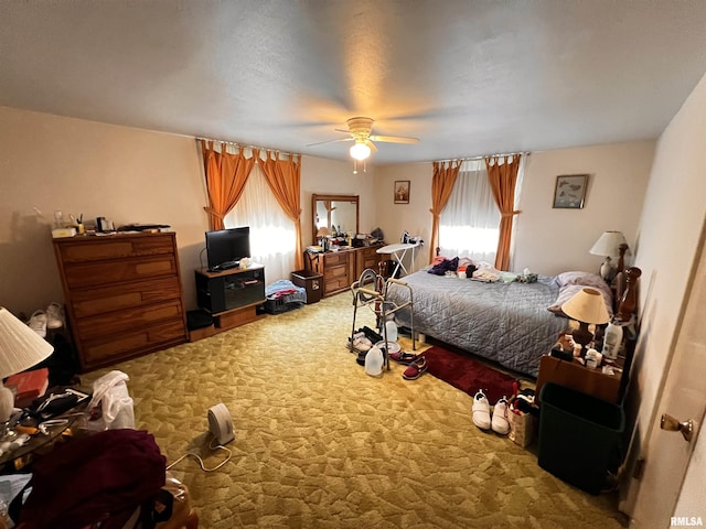 bedroom featuring multiple windows, a ceiling fan, and carpet flooring