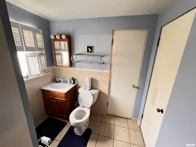 bathroom featuring tile walls, tile patterned flooring, wainscoting, vanity, and toilet